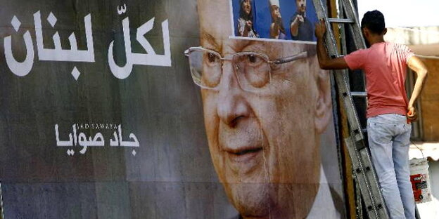 Junger Mann klebt ein Wahlplakat im Libanon Junger Mann klebt ein Wahlplakat im Libanon