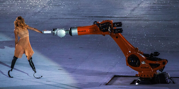Ein Roboter und eine Frau mit Beinprothesen Ein Roboter und eine Frau mit Beinprothesen