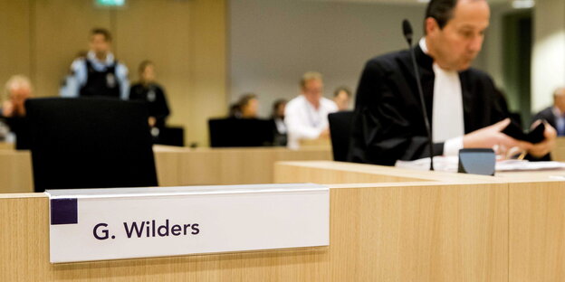 Der Platz von Geert Wilders im Gericht ist leer, nur sein Verteidiger sitzt rechts im Bild Der Platz von Geert Wilders im Gericht ist leer, nur sein Verteidiger sitzt rechts im Bild