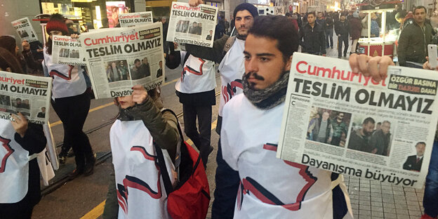 Demonstranten halten eine Ausgabe der Cumhuriyet hoch Demonstranten halten eine Ausgabe der Cumhuriyet hoch