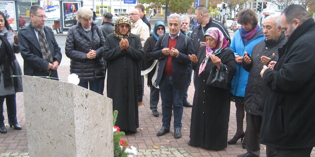 Viele Menschen vor einem Gedenkstein Viele Menschen vor einem Gedenkstein