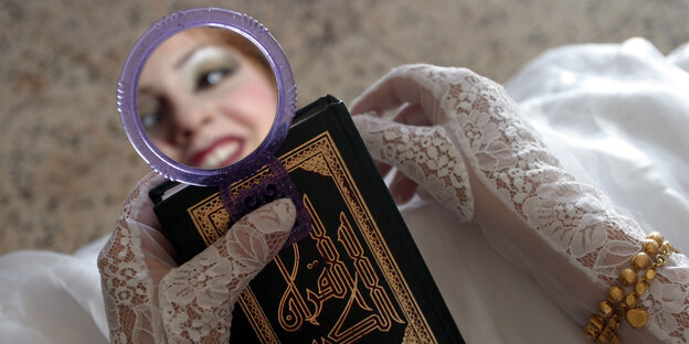 Das Gesicht einer Braut in einem Handspiegel, darunter ein Koran Das Gesicht einer Braut in einem Handspiegel, darunter ein Koran