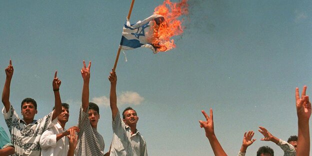 Palästinensische Jugendliche verbrennen eine israelische Flagge Palästinensische Jugendliche verbrennen eine israelische Flagge