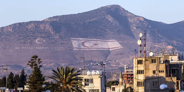 Von der griechischen Seite sieht man die türkische Flagge auf einem Berg auf der türkischen Seite von Nicosia Von der griechischen Seite sieht man die türkische Flagge auf einem Berg auf der türkischen Seite von Nicosia