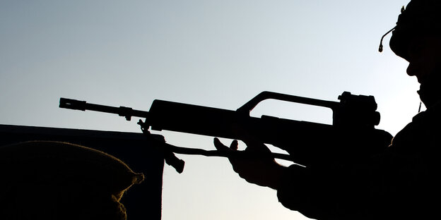 Schwarze Silhouette eines Soldaten, der sein Gewehr hält Schwarze Silhouette eines Soldaten, der sein Gewehr hält