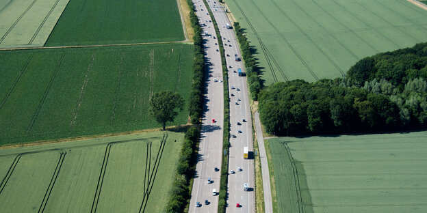 Eine Autobahn durchschneidet Felder und Wiesen. Eine Autobahn durchschneidet Felder und Wiesen.