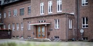 Ein grau-brauner Backsteinbau, an dem „Evangelisches Gymnasium zum grauen Kloster“ steht