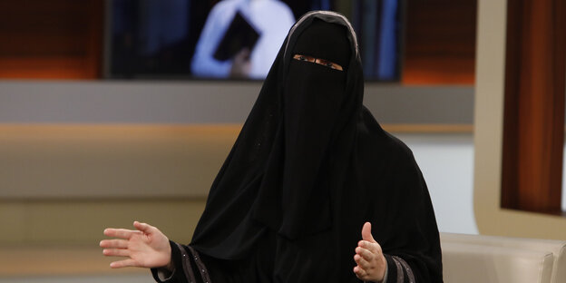 Die mit einem Niqab vollverschleierte Nora Illi sitzt im Studio von Anne Will und hebt beim Sprechen die Hände Die mit einem Niqab vollverschleierte Nora Illi sitzt im Studio von Anne Will und hebt beim Sprechen die Hände