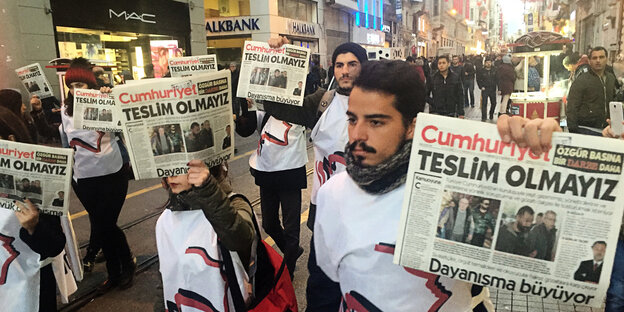 Menschen in weißen T-Shirts laufen mit Ausgaben der Zeitung "Cumhuriyet" in der Hand die Istiklal-Straße in Instanbul entlang Menschen in weißen T-Shirts laufen mit Ausgaben der Zeitung "Cumhuriyet" in der Hand die Istiklal-Straße in Instanbul entlang