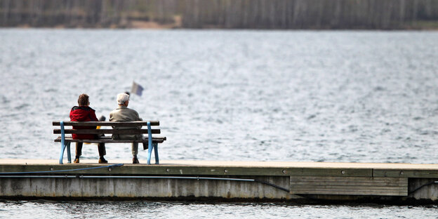 Zwei ältere Menschen auf einer Bank am See Zwei ältere Menschen auf einer Bank am See
