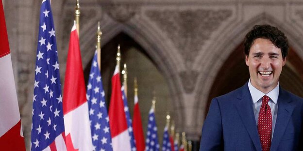 Präsident Trudeau läuft an Kanada- und USA-Flaggen vorbei Präsident Trudeau läuft an Kanada- und USA-Flaggen vorbei