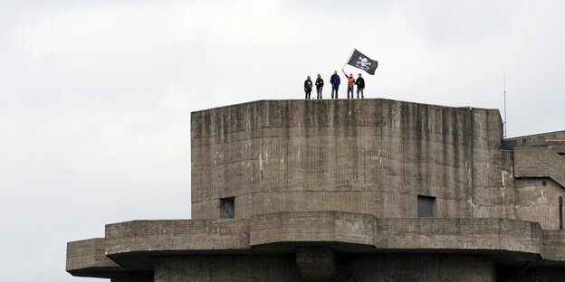 Fans des FC St. Pauli stehen fahnenschwenkend auf dem Dach des alten Flakbunkers an der Feldstraße.