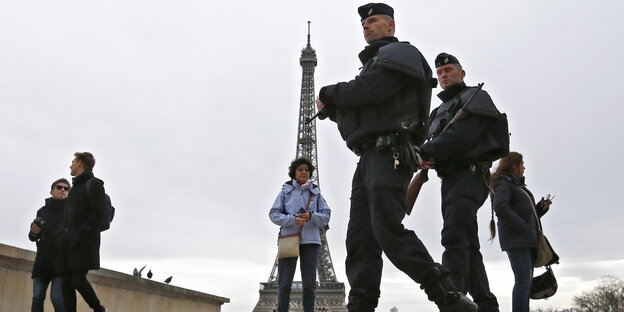 Polizisten und Touristen vor dem Eiffelturm in Paris Polizisten und Touristen vor dem Eiffelturm in Paris