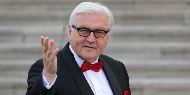 Steinmeier im Anzug mit Fliege, macht Geste mit der Hand in Richtung Kamera