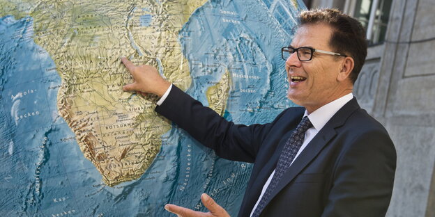 Gerd Müller zeigt an einem großen Globus auf Afrika Gerd Müller zeigt an einem großen Globus auf Afrika