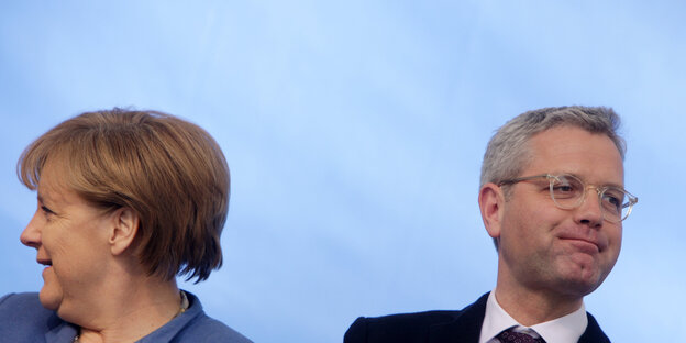 Zwei Menschen schauen aus dem Bild. Es sind Angela Merkel und Norbert Röttgen Zwei Menschen schauen aus dem Bild. Es sind Angela Merkel und Norbert Röttgen
