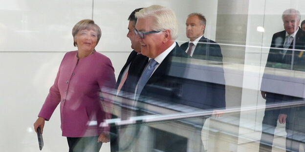 Merkel, Gabriel und Steinmeier laufen hinter einer Glasscheibe Merkel, Gabriel und Steinmeier laufen hinter einer Glasscheibe