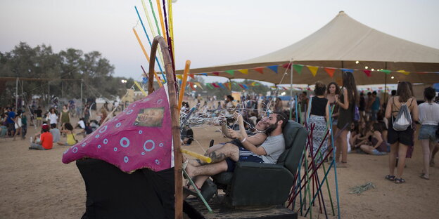 Festivalbesucher probieren eine Kunst-Installation auf dem InDnegev-Festival aus. Festivalbesucher probieren eine Kunst-Installation auf dem InDnegev-Festival aus.