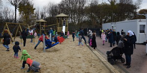 Kinder spielen auf dem neuen Spielplatz neben den Wohncontainern der Erstaufnahme an der Hamburger Papenreye.