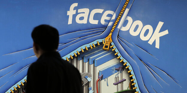 Mann vor einem Facebook-Wandgemälde Mann vor einem Facebook-Wandgemälde