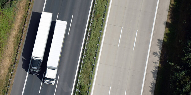 Vogelperspektive auf zwei Lastwagen während eines Überholmanövers auf der Autobahn Vogelperspektive auf zwei Lastwagen während eines Überholmanövers auf der Autobahn