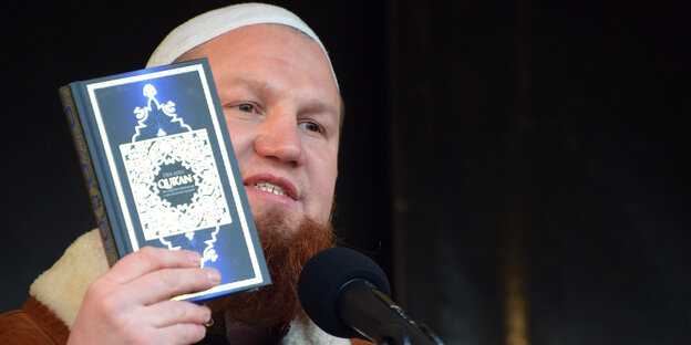 Islam-Prediger Pierre Vogel hält bei einer Kundgebung einen Koran hoch Islam-Prediger Pierre Vogel hält bei einer Kundgebung einen Koran hoch