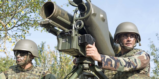 Zwei Männer in Uniform bedienen einen Raketenwerfer Zwei Männer in Uniform bedienen einen Raketenwerfer