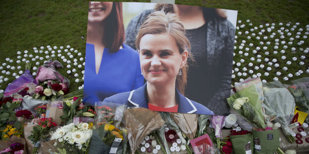 Ein großes Portraitbild zwischen Kerzen und Blumen Ein großes Portraitbild zwischen Kerzen und Blumen