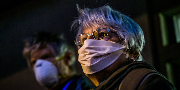 Eine Frau mit einer Maske, die sie gegen Abgase schützt Eine Frau mit einer Maske, die sie gegen Abgase schützt