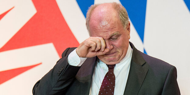 Uli Hoeneß weinend vor einem Logo des FC Bayern