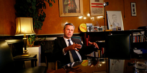 Der österreichische Politiker Norbert Hofer sitzt an einem Tisch in einem vollgestellten Büro Der österreichische Politiker Norbert Hofer sitzt an einem Tisch in einem vollgestellten Büro