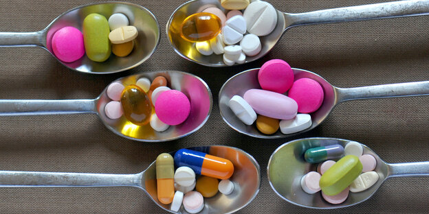 Tabletten in verschiedenen Farben auf Teelöffeln Tabletten in verschiedenen Farben auf Teelöffeln