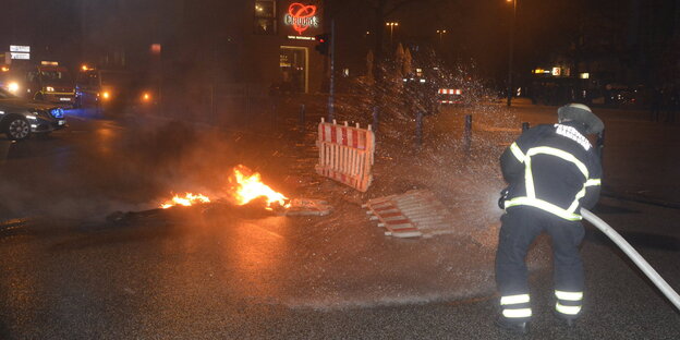 ein Feuerwehrmann löscht ein Feuer auf einer Straße ein Feuerwehrmann löscht ein Feuer auf einer Straße