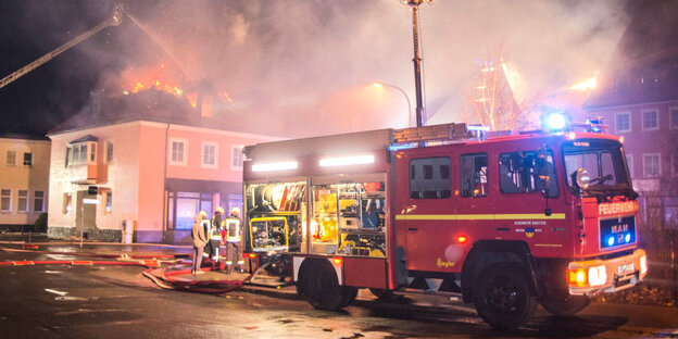 Ein Feuerwehrfahrzeug steht in Bautzen vor einer brennenden geplanten Flüchtlingsunterkunft. Ein Feuerwehrfahrzeug steht in Bautzen vor einer brennenden geplanten Flüchtlingsunterkunft.