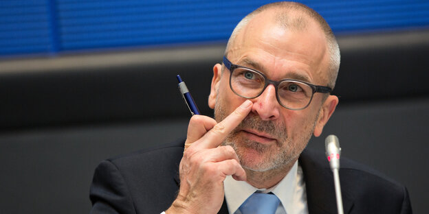 Ein Mann fässt sich an die Nase Ein Mann fässt sich an die Nase