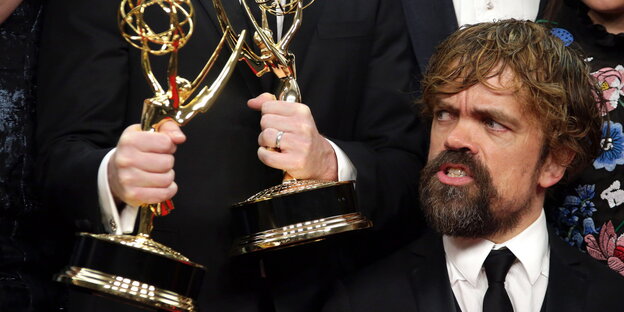 US-Schauspieler Peter Dinklage guckt ehrfürchtig auf zwei Awards US-Schauspieler Peter Dinklage guckt ehrfürchtig auf zwei Awards
