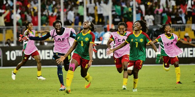 Jubelende Spielerinnen der kamerunsichen Mannschaft im Stadion in der Hauptstadt Kameruns Yaoundé. Im Hintergrund jubelnde Fans. Jubelende Spielerinnen der kamerunsichen Mannschaft im Stadion in der Hauptstadt Kameruns Yaoundé. Im Hintergrund jubelnde Fans.