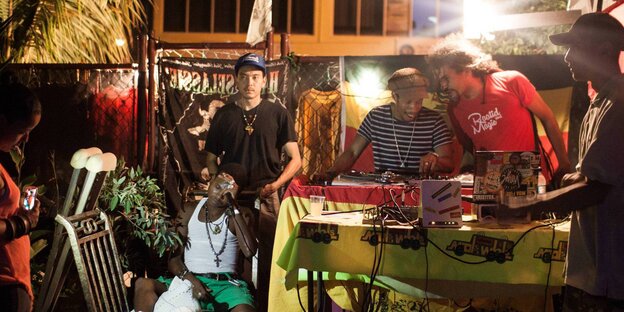 Männer stehen neben einem DJ-Pult Männer stehen neben einem DJ-Pult