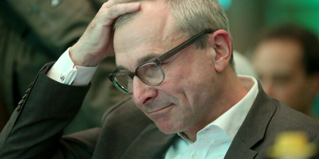 Ein Mann fässt sich an den Kopf Ein Mann fässt sich an den Kopf