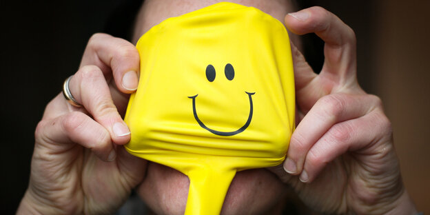 Smiley vor einem Gesicht Smiley vor einem Gesicht