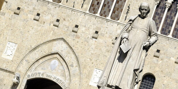 Eine Statue vor einer altertümlichen Hausfassade Eine Statue vor einer altertümlichen Hausfassade