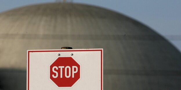 Die Kuppel eines Atomreaktors, davor ein Stop-Schild Die Kuppel eines Atomreaktors, davor ein Stop-Schild