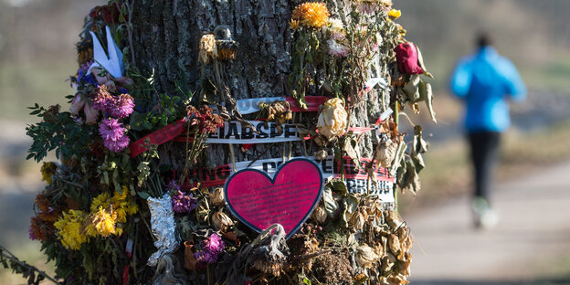 Blumen und Trauerschmuck an einem Baum befestigt Blumen und Trauerschmuck an einem Baum befestigt