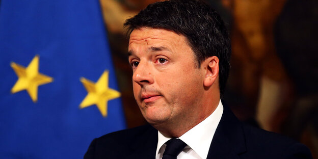Italiens Ministerpräsident Matteo Renzi steht vor einer EU-Flagge und guckt bedrückt Italiens Ministerpräsident Matteo Renzi steht vor einer EU-Flagge und guckt bedrückt