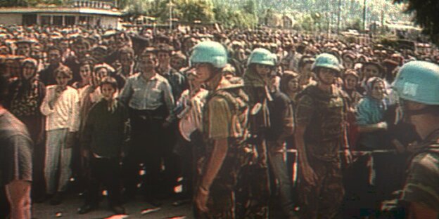Hunderte Zivilisten und UN-Soldaten i stehen auf einem Platz in Bosnien-Herzegowina Hunderte Zivilisten und UN-Soldaten i stehen auf einem Platz in Bosnien-Herzegowina