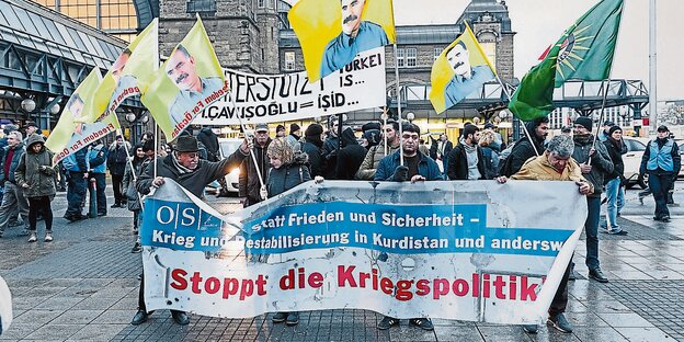 Menschen demonstrieren mit einem Transparent, auf dem steht: Stoppt die Kriegspolitik Menschen demonstrieren mit einem Transparent, auf dem steht: Stoppt die Kriegspolitik