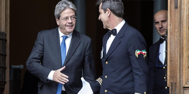 Paolo Gentiloni verabschiedet sich mit Handschlag bei einen Angestellten Paolo Gentiloni verabschiedet sich mit Handschlag bei einen Angestellten