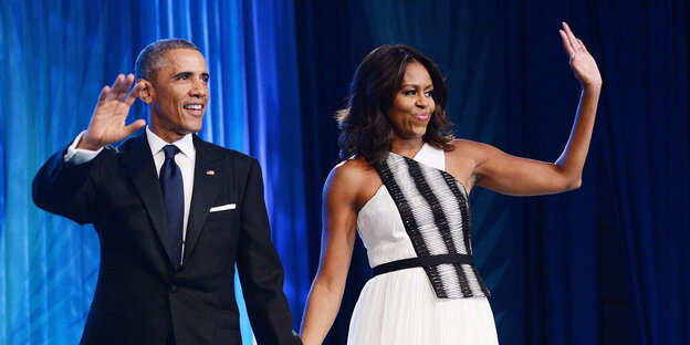 Michelle und Barack Obama winken von einer Bühne Michelle und Barack Obama winken von einer Bühne