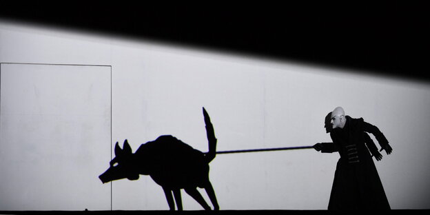 Szene aus der Zauberflöte an der Oper in Warschau, in der ein Schauspieler einen Schattenwolf an der Leine führt Szene aus der Zauberflöte an der Oper in Warschau, in der ein Schauspieler einen Schattenwolf an der Leine führt
