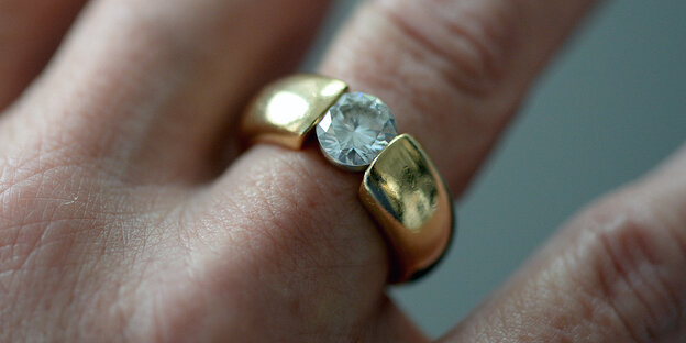 Frauen an Hand mit einem Diamantring am Finger Frauen an Hand mit einem Diamantring am Finger